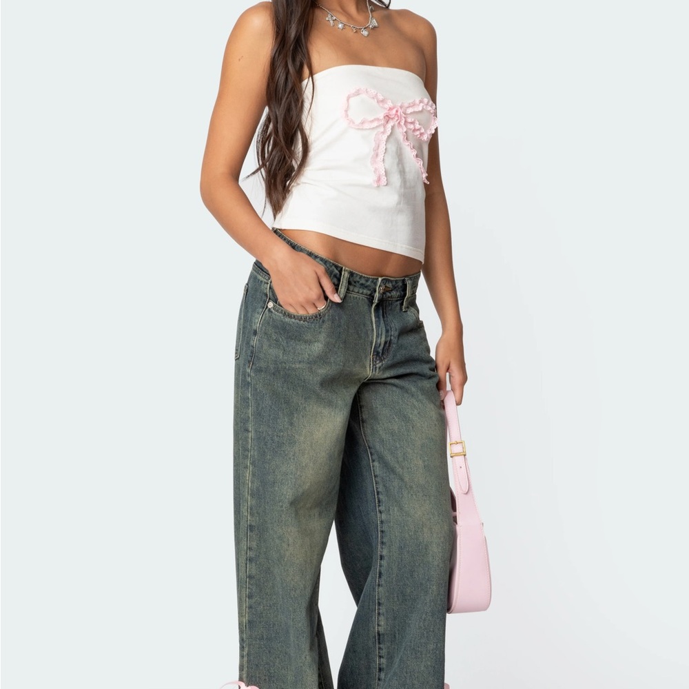 Edikted Blue Flare Wide Leg Jeans with slits and pink bows at the bottom.